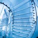 futuristic glass spiral staircase with modern building background