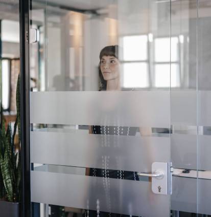 Businesswoman standing behind glass door