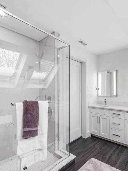 A white minimalist bathroom interior with glass partition
